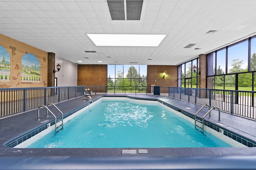 A large indoor swimming pool with a mural on the wall.