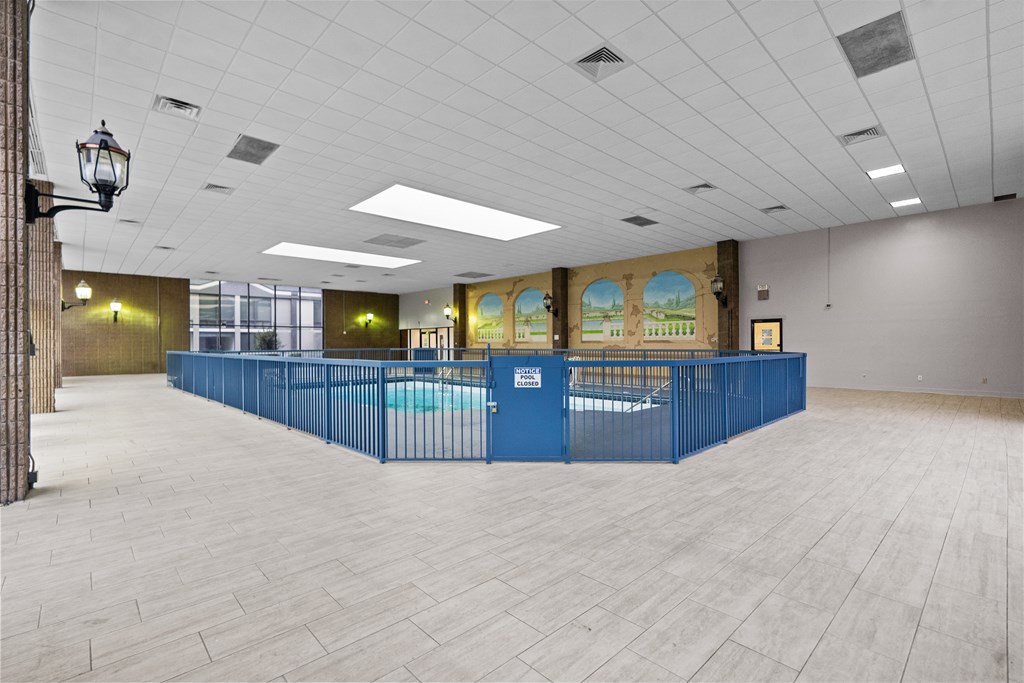 A large room with a long blue table and a pool table.