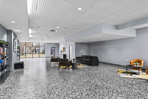 A spacious room with a grey floor and furniture.