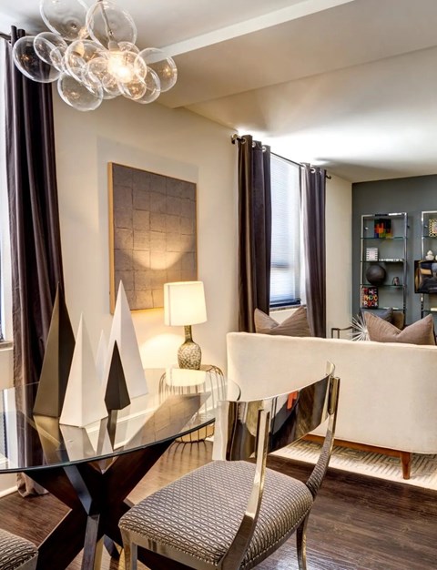 A modern dining room with a glass table and chairs.
