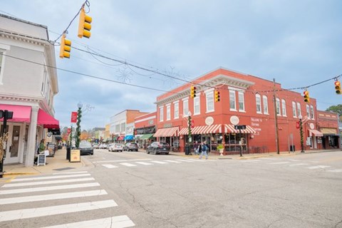 A street view of a city intersection with traffic lights and buildings.