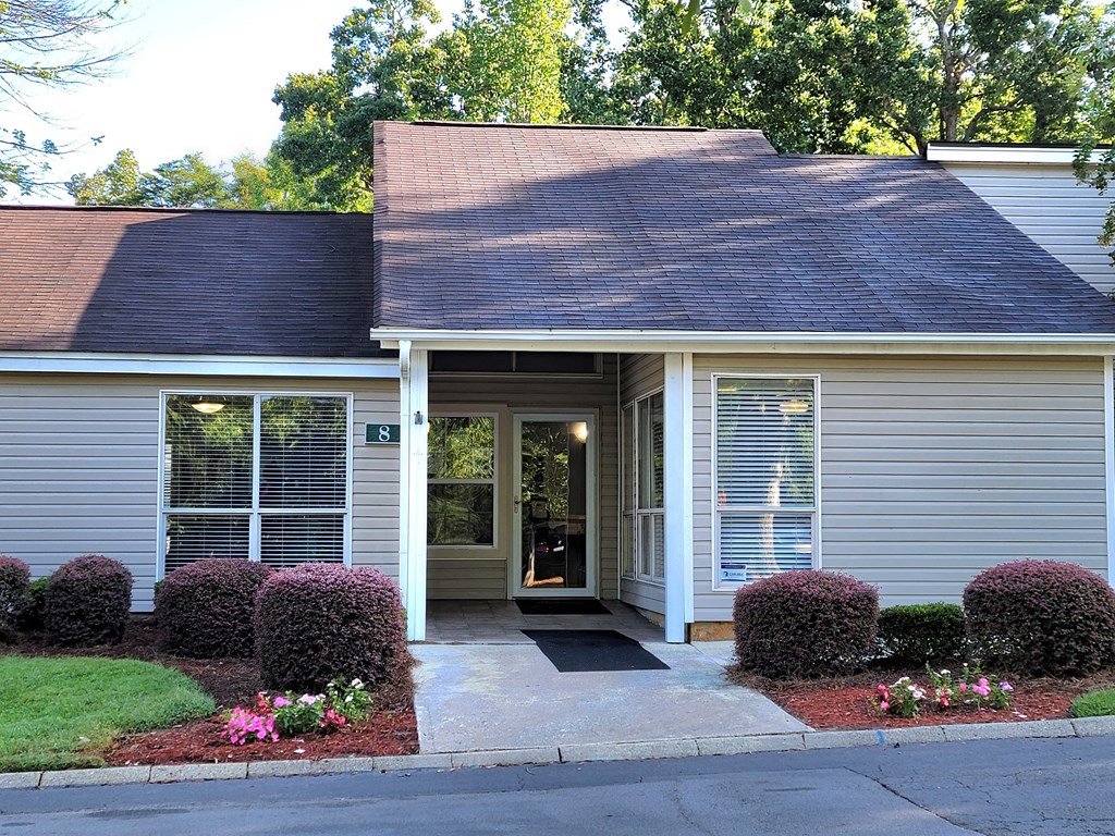 a small white house with a porch and a front door