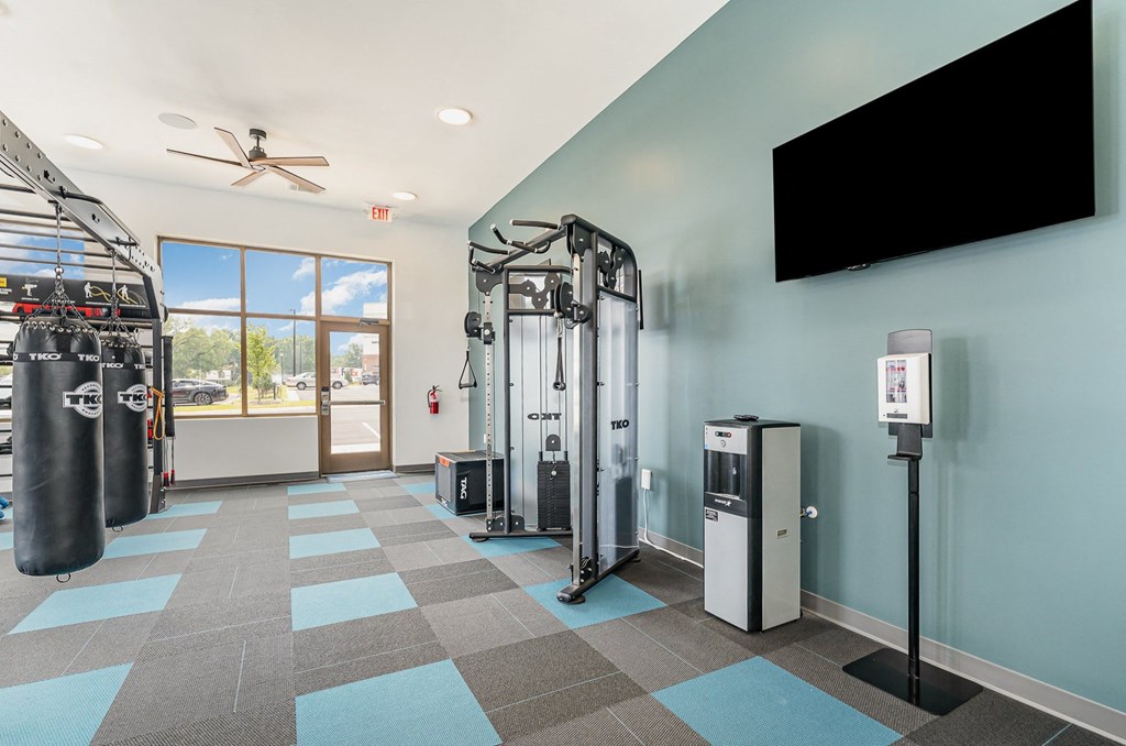 a fitness room with cardio equipment and a flat screen tv