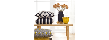 a table with pillows and a vase with flowers on it