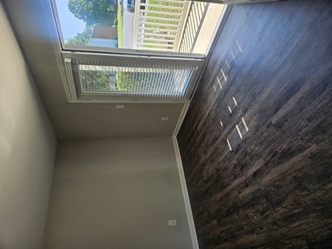 A room with a skylight and a wooden wall.