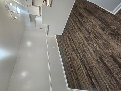 A staircase with a wooden floor and white walls.