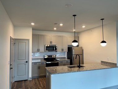 a kitchen with white cabinets and a granite counter top