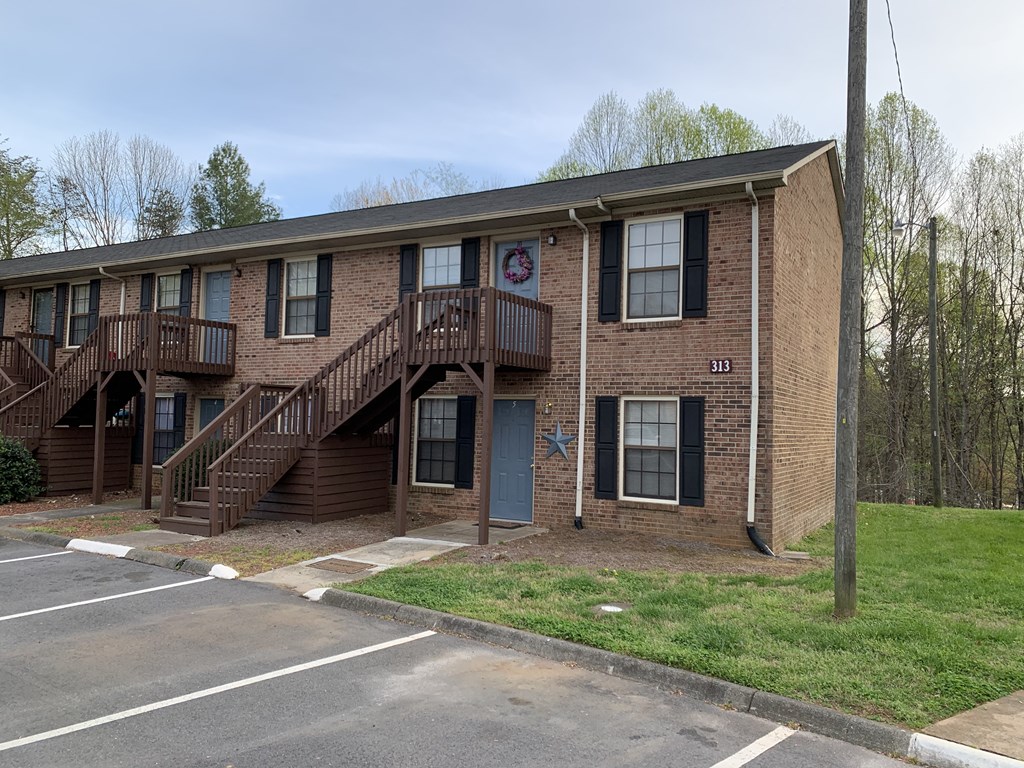 A brick building with a blue star on the door and a red and white sign on the window.