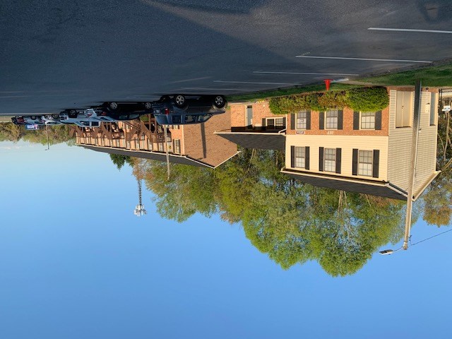 A reflection of a building and cars in a body of water.