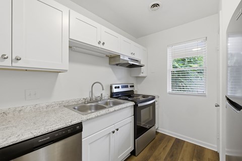 A kitchen with white cabinets and a granite countertop.