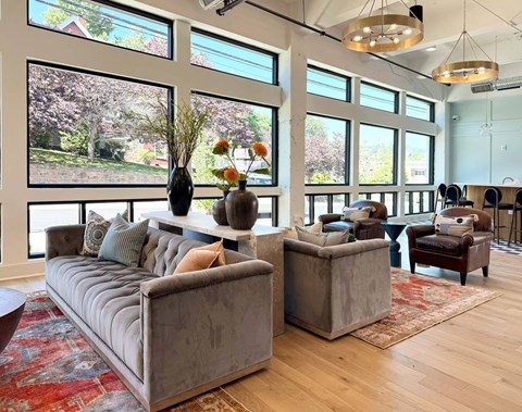 A living room with a grey sofa and a wooden floor.