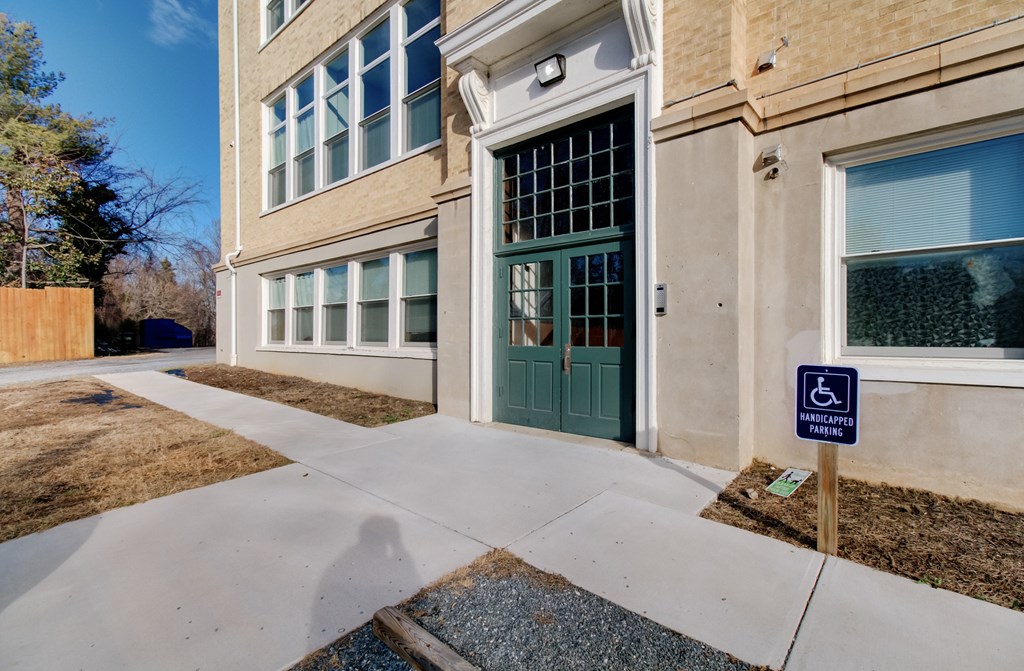 A building with a green door and a handicap sign in front.