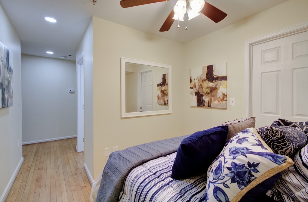 A bedroom with a bed and a ceiling fan.