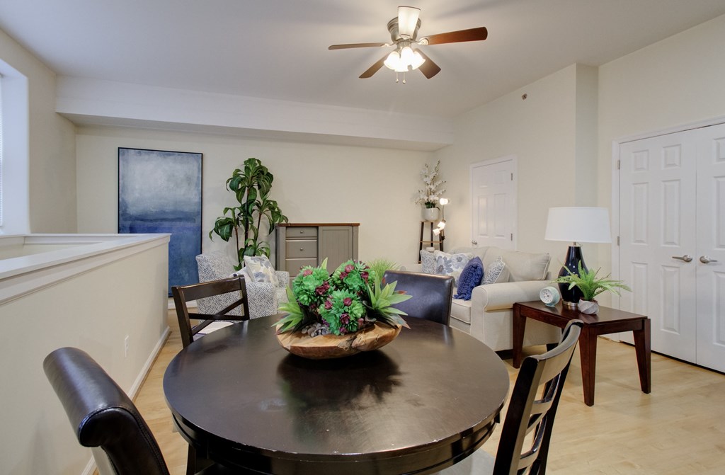 A dining room with a table set for two and a plant on the table.