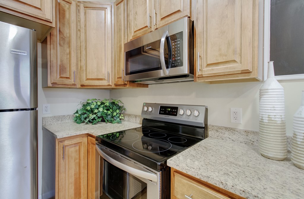 A kitchen with a stove, oven, microwave, and refrigerator.