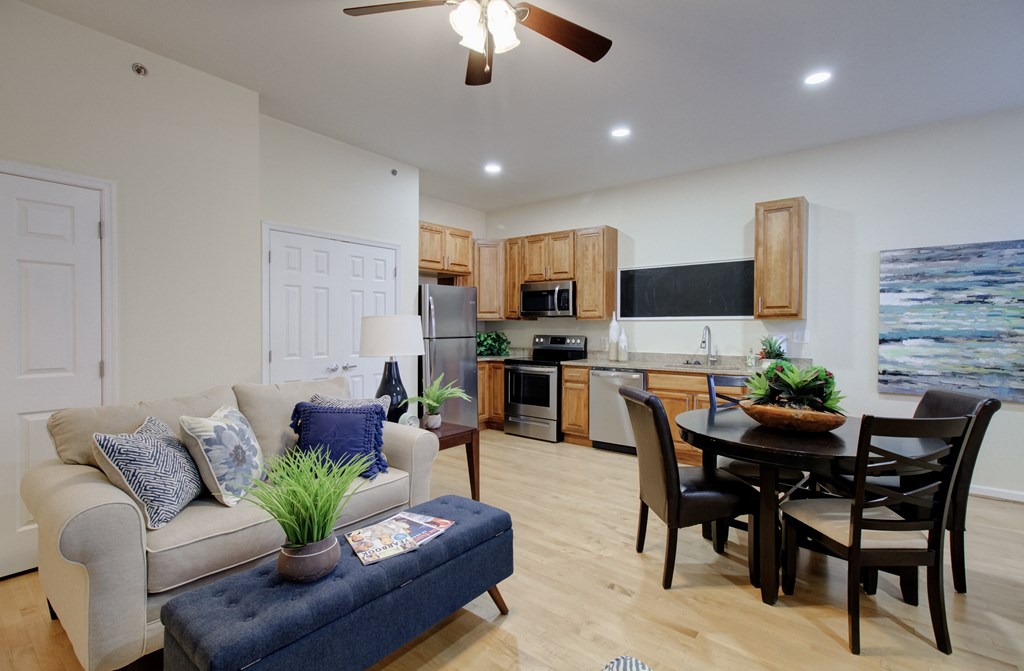 A living room with a couch, a table, and a ceiling fan.