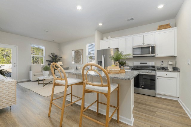 A kitchen with a table and chairs in front of it.