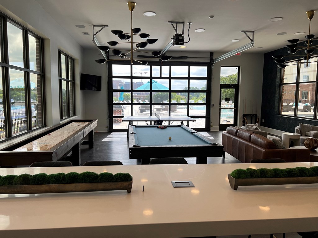 a large room with a pool table and couches