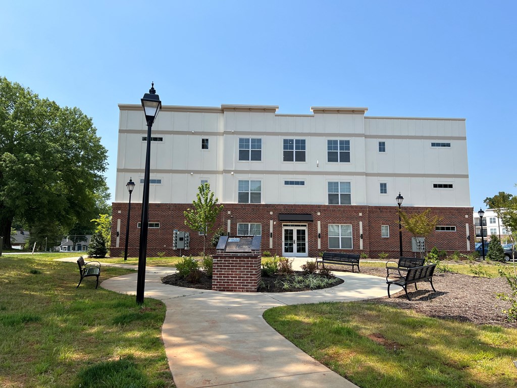 a brick building with a walkway and benches in front of it