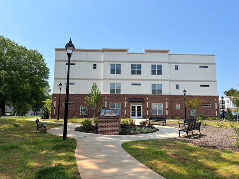 a brick building with a walkway and benches in front of it