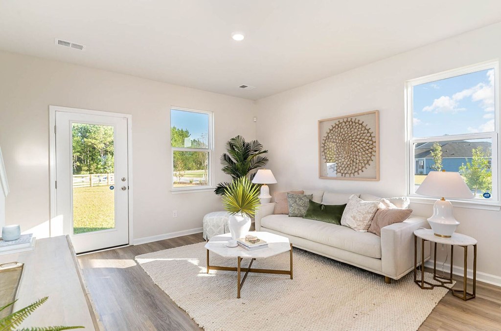 A well-lit living room with a white sofa and a coffee table.