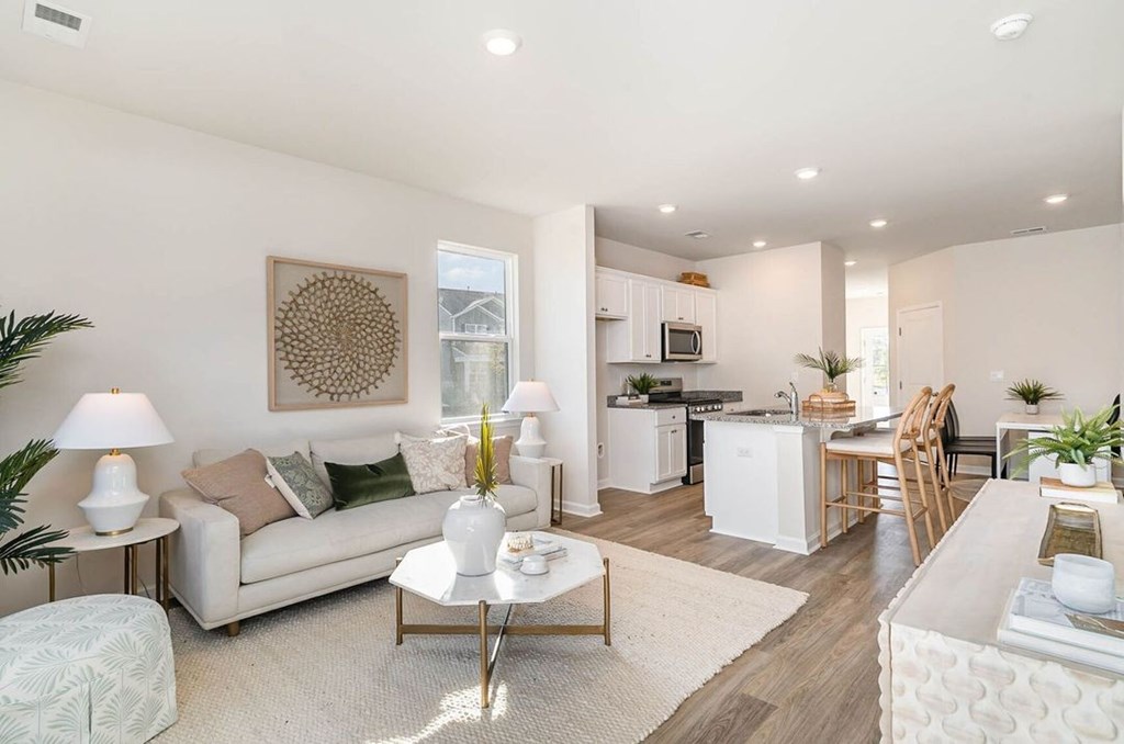 A well-lit, modern living room with a white sofa and a coffee table.