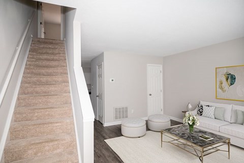 A living room with a staircase leading to the upper floor.