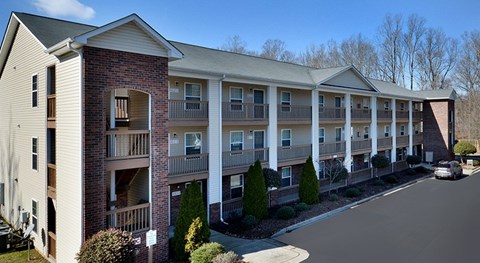 Apartment building with a car parked in front.