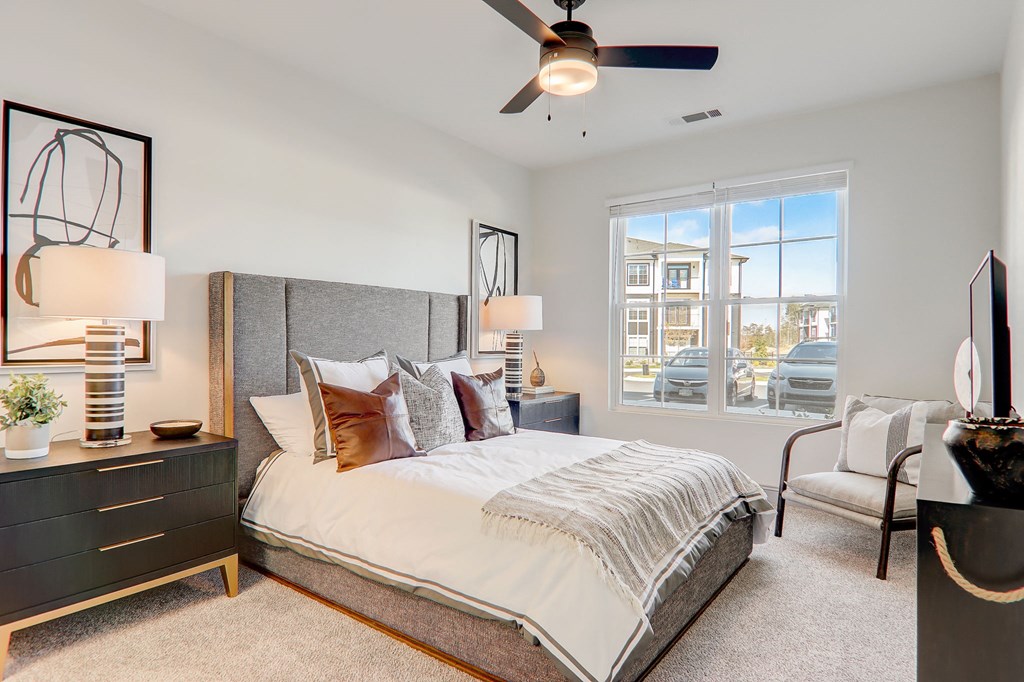 a bedroom with a large bed and a ceiling fan