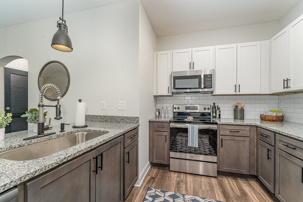 a kitchen with white cabinets and granite countertops