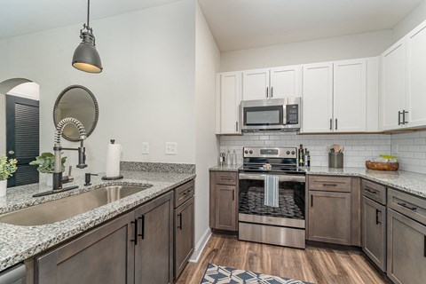 a kitchen with white cabinets and granite countertops