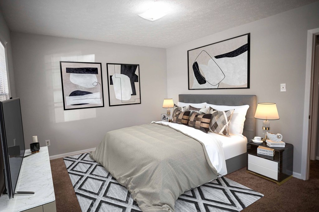 A bedroom with a bed, nightstand, and two framed pictures on the wall.