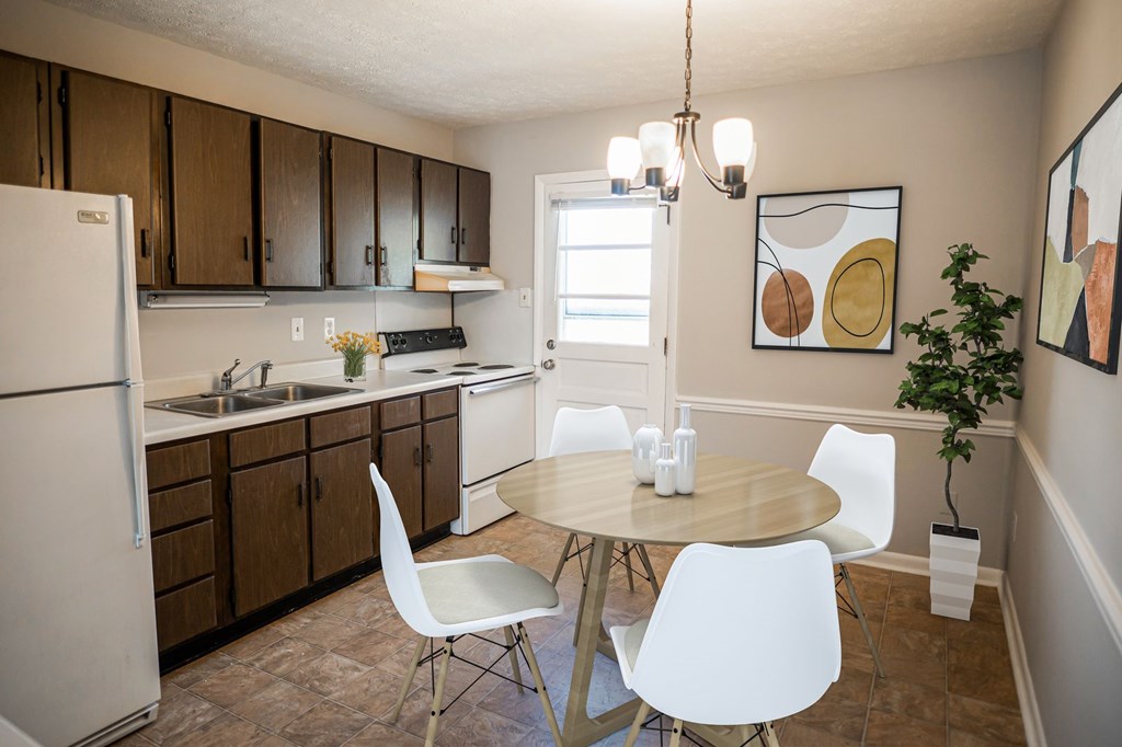 A kitchen with a table and chairs.