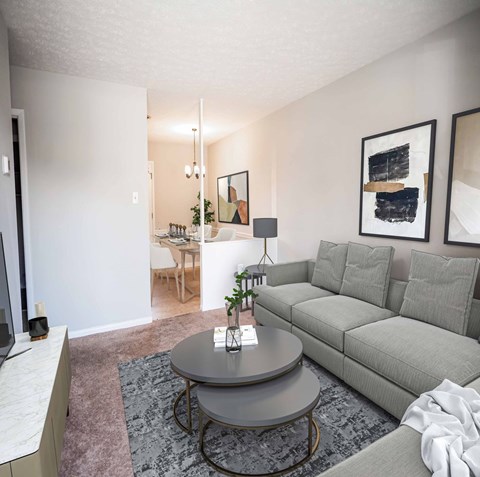 A grey couch sits in a living room with a table in front of it.
