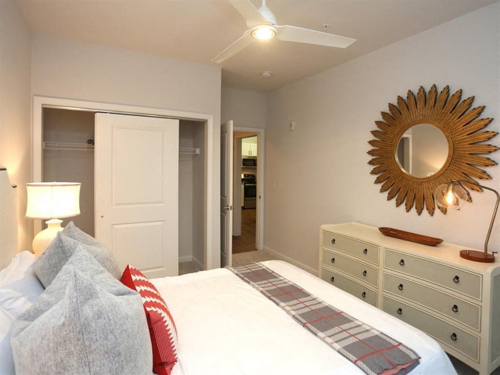 a bedroom with a bed and a mirror on the wall