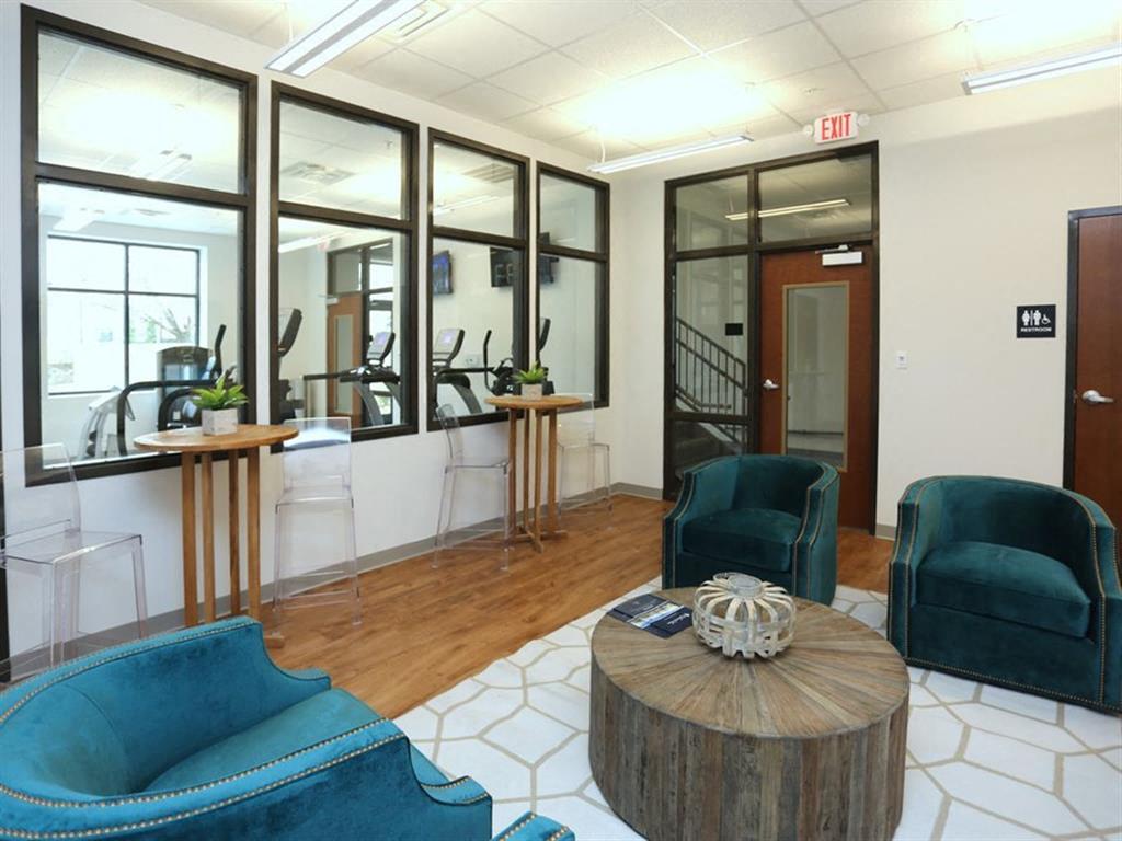 a lobby with blue chairs and a coffee table