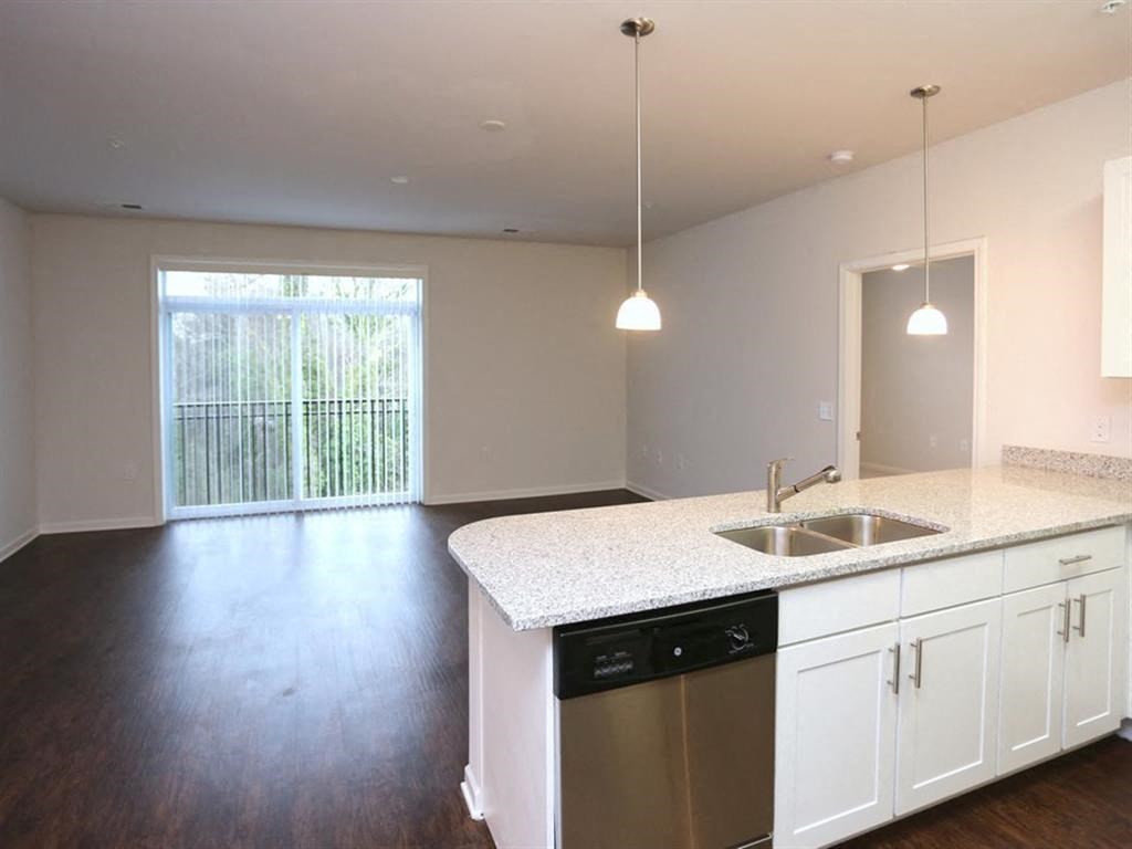 an empty kitchen with white cabinets and a sink