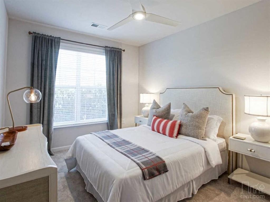 a bedroom with a white bed and a window