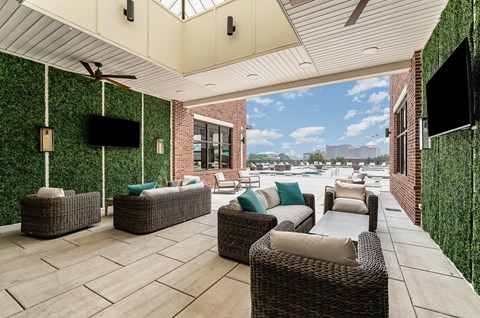a covered patio with wicker furniture and a flat screen tv