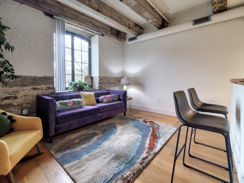 A living room with a purple couch and a yellow chair.