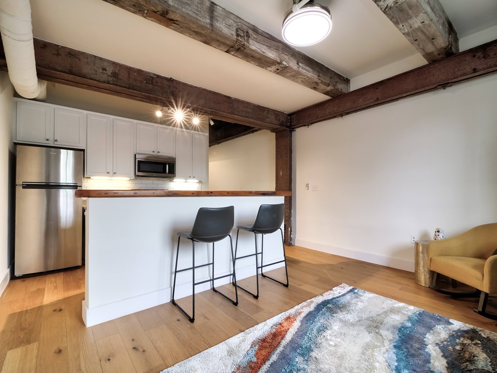 A kitchen with a white counter and a fridge.