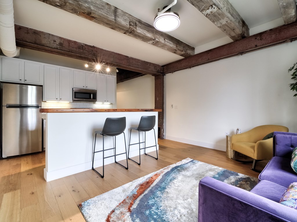 A kitchen with a white counter and a purple couch.