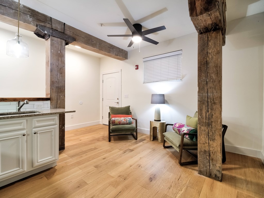 A room with wooden floors and a large wooden pillar.