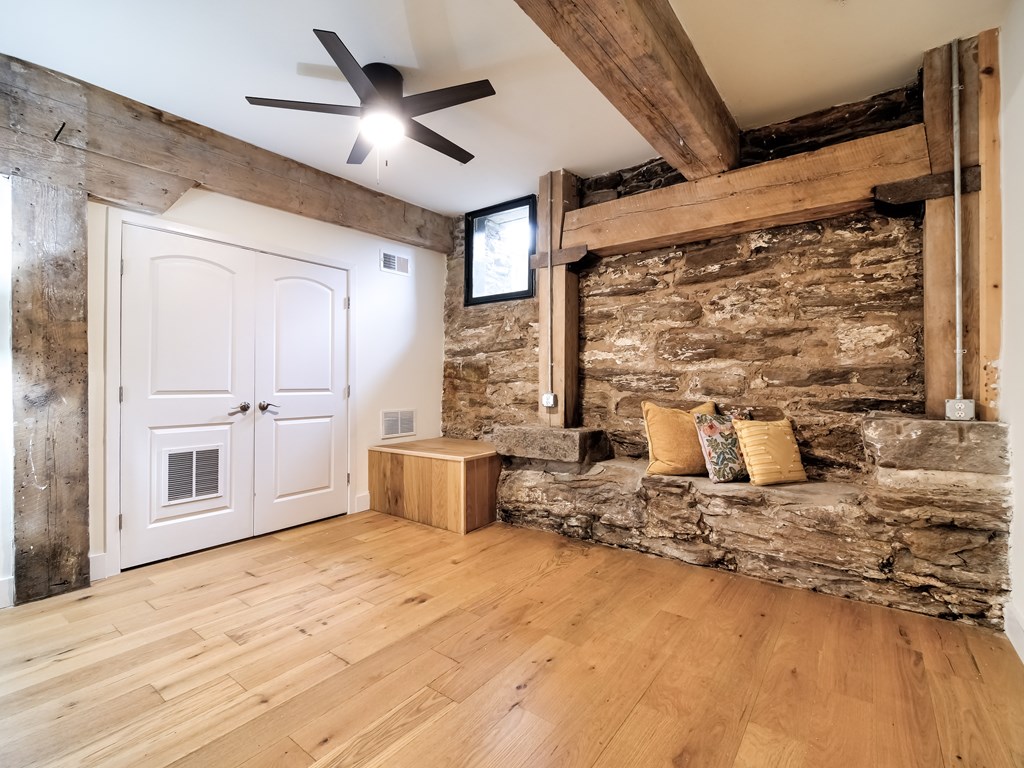 A room with a white door and a stone wall.