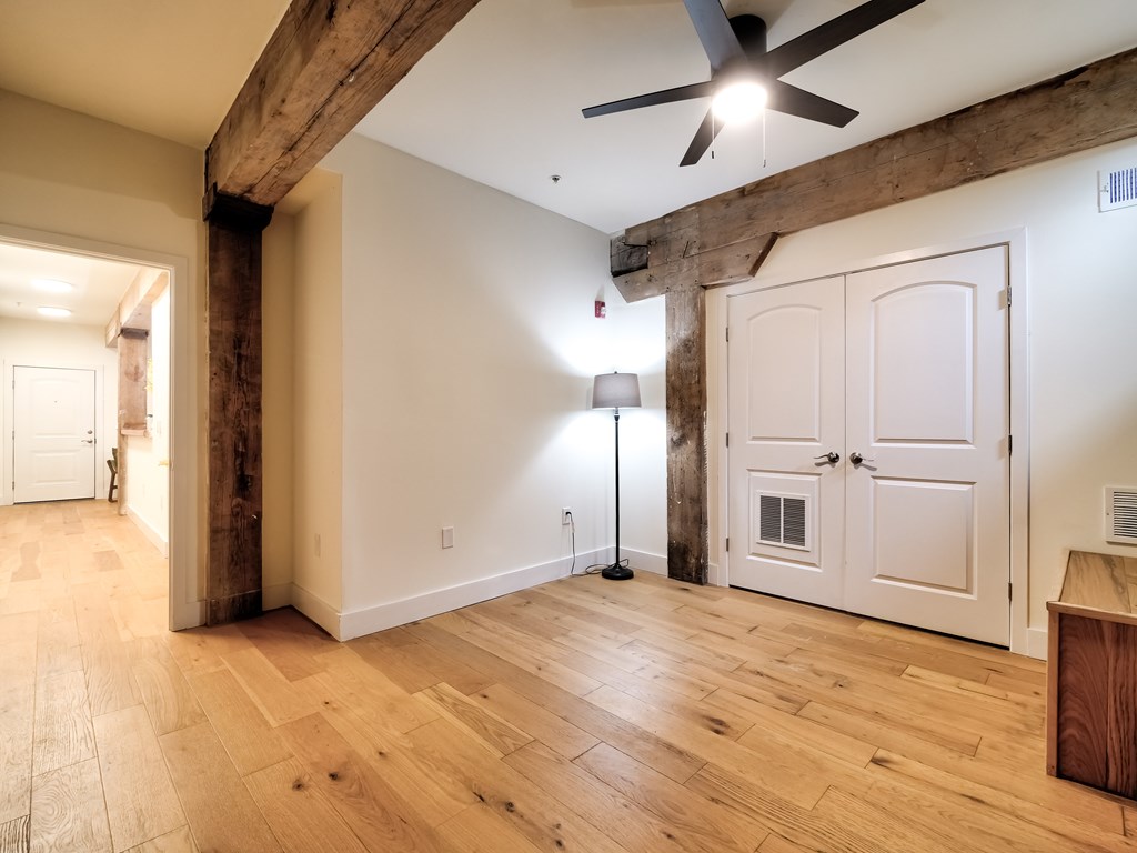 A room with wooden floors and a ceiling fan.