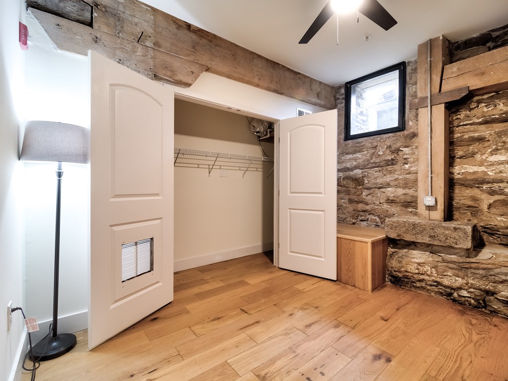 A room with a wooden floor and a stone wall.