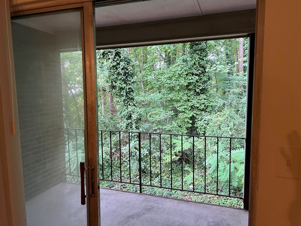 a room with a view of a balcony and trees