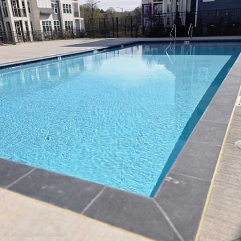 A large blue swimming pool with a black fence around it.
