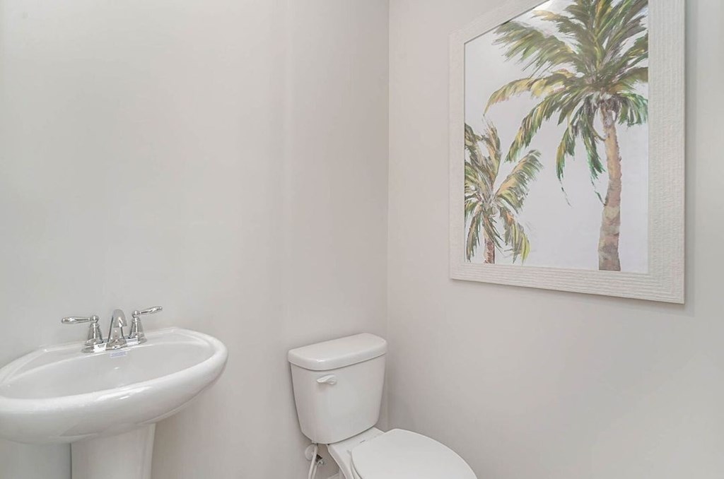 A white toilet sits next to a white sink in a bathroom.
