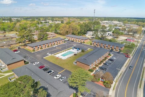 A parking lot with a pool in the middle of a building complex.